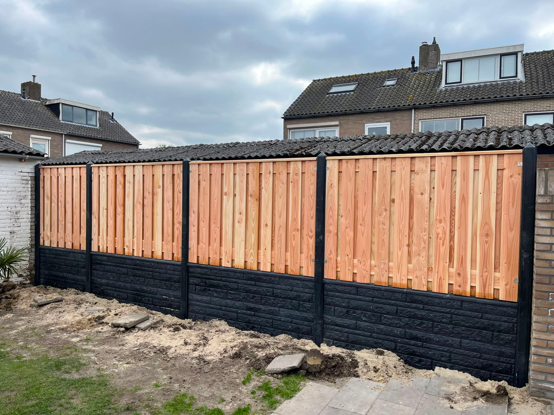 Door OK Houten Schuttingen geplaatste douglas schutting met antraciet rotsmotief onderplaten